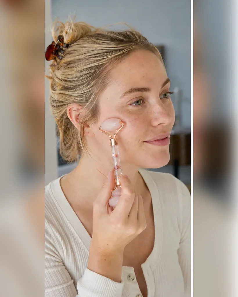 Model using a rose quartz facial roller